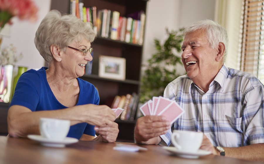 elderly couple playing cards at a table