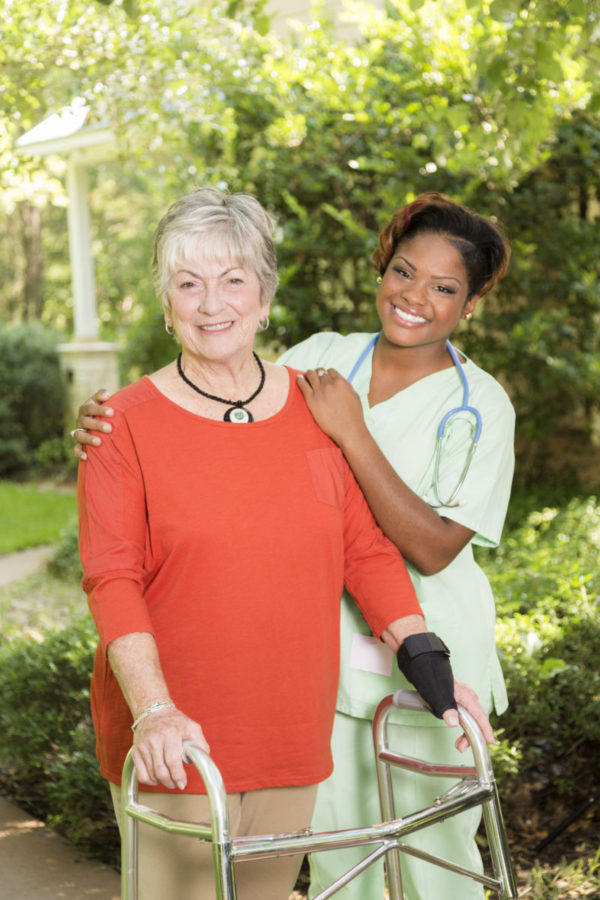 Home caregiver, nurse with senior adult patient outdoors