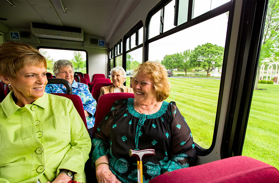 Seniors laugh on the bus together