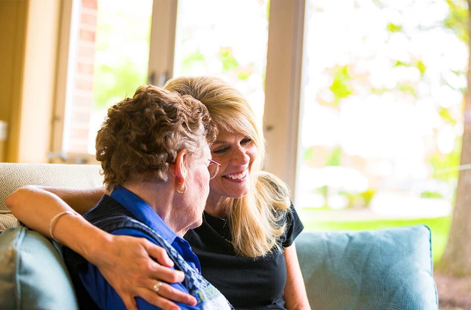 Senior woman and adult daughter hug