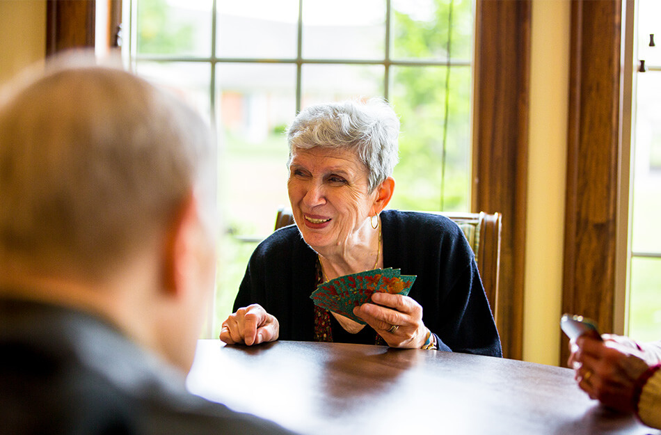 senior woman plays cards with friends