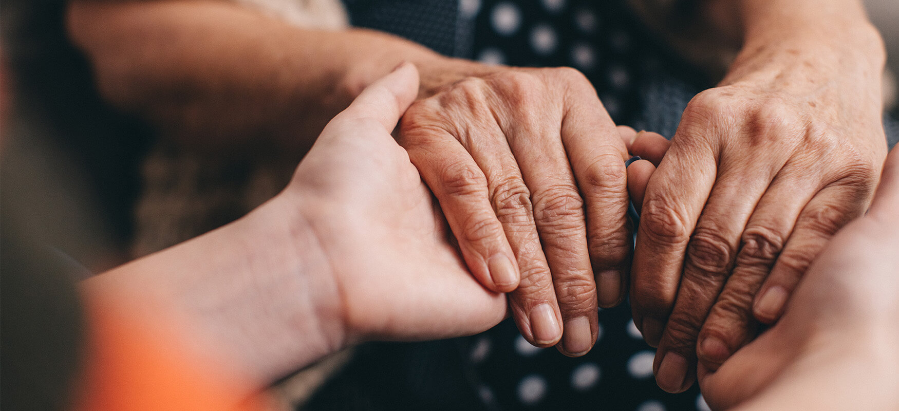 Senior woman hold hands with younger adult