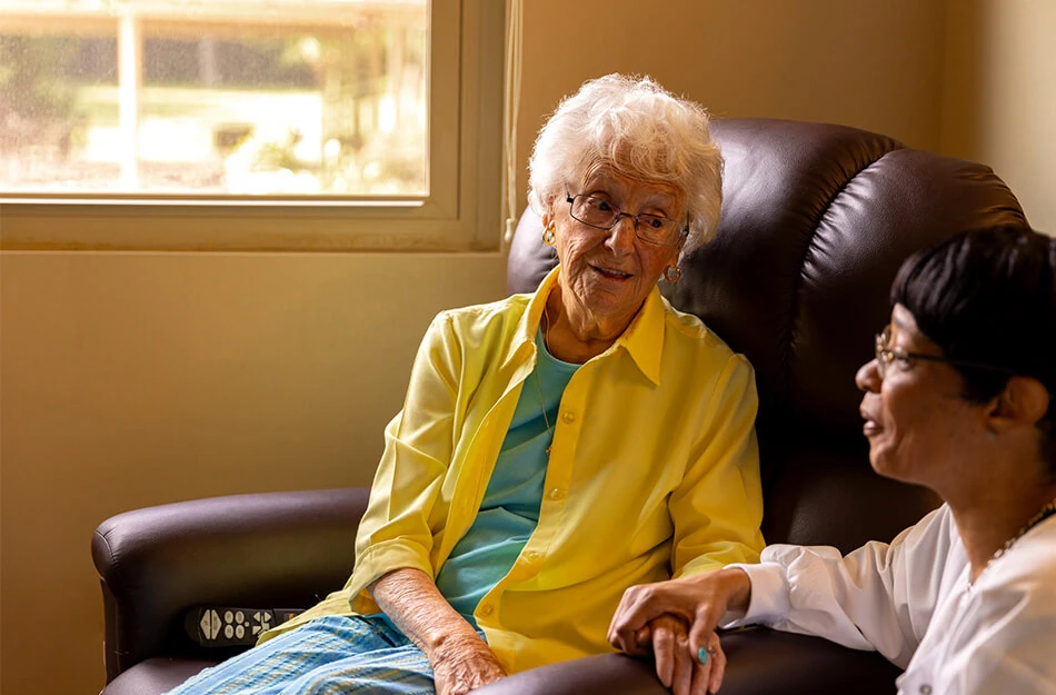 nurse holds senior woman's hand