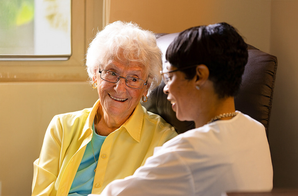 Senior woman and nurse speak together