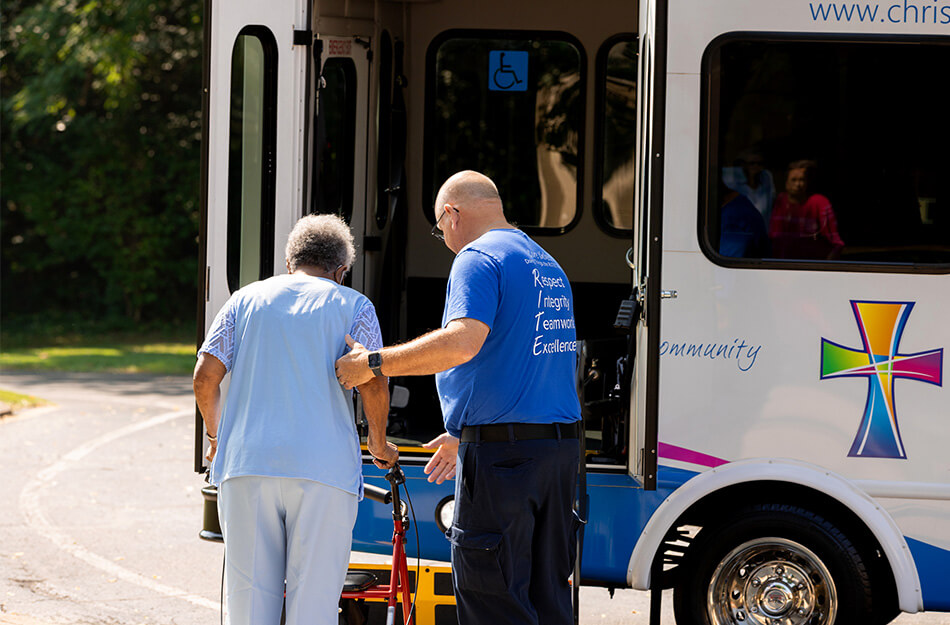Senior woman enters bus with assistance