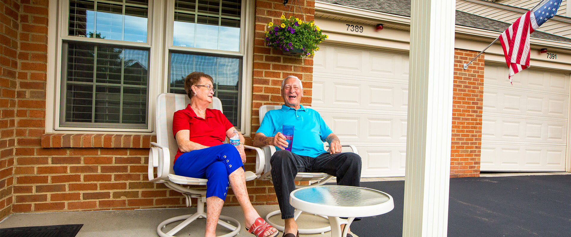 Senior couple sits on porch relaxing