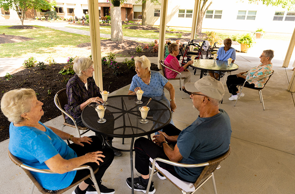 Senior friends sit around a table and enjoy a sundae