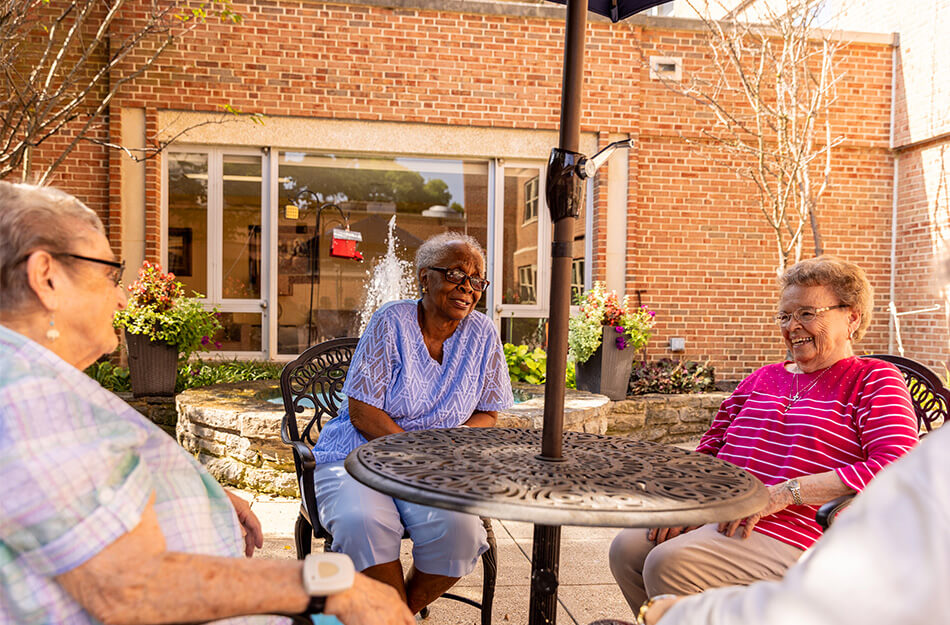 Seniors laughing around a table outside