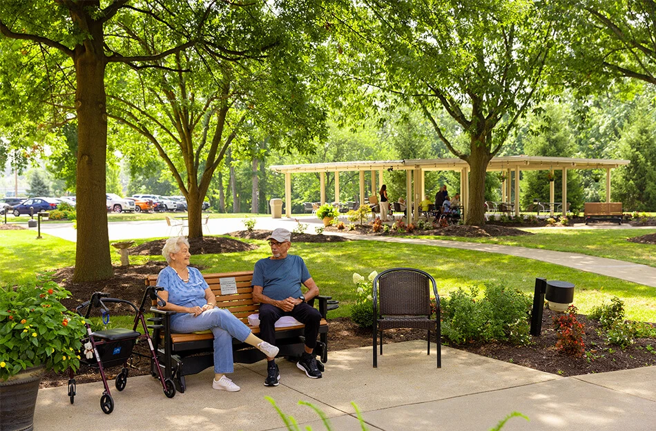 Senior friends sit on bench outdoors