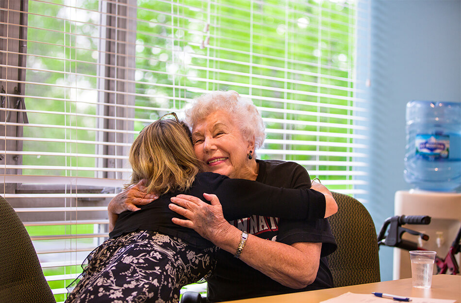 Senior hugs young woman