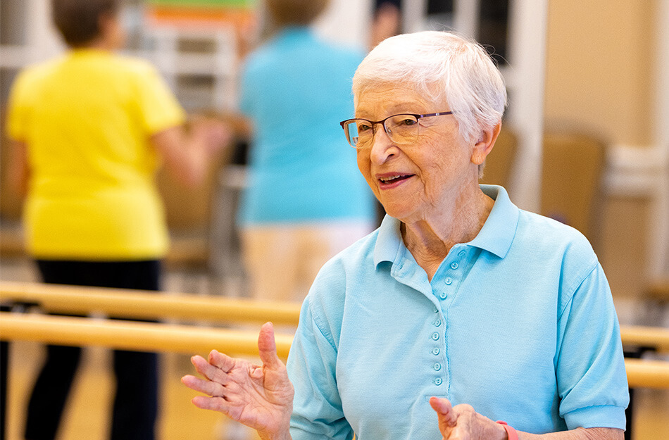 Senior woman clapping in exercise class
