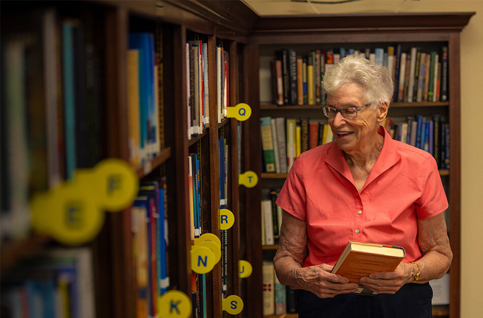 Senior woman looking around a library