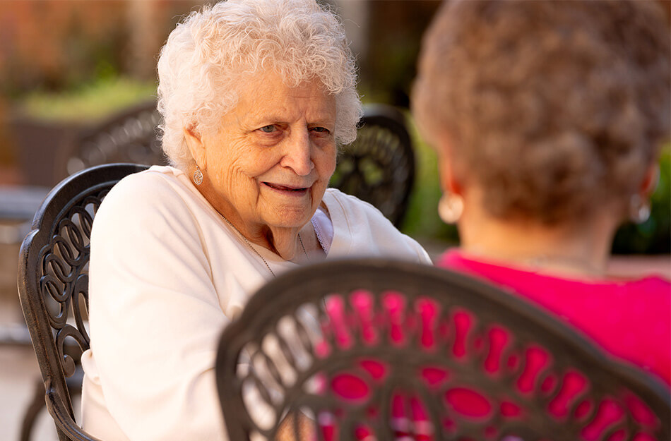 Senior women sit together and laugh