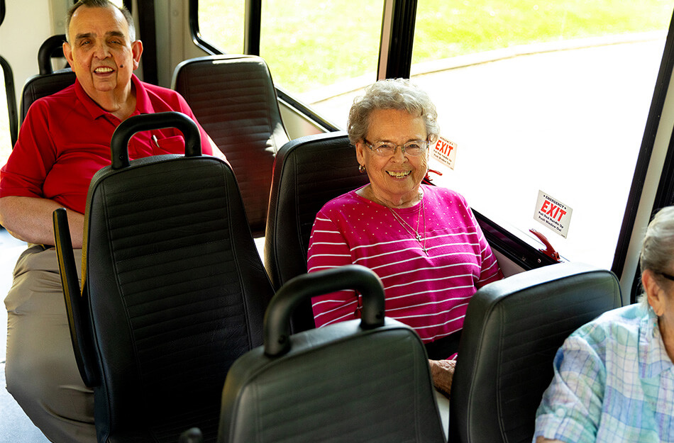 Seniors on a bus smiling