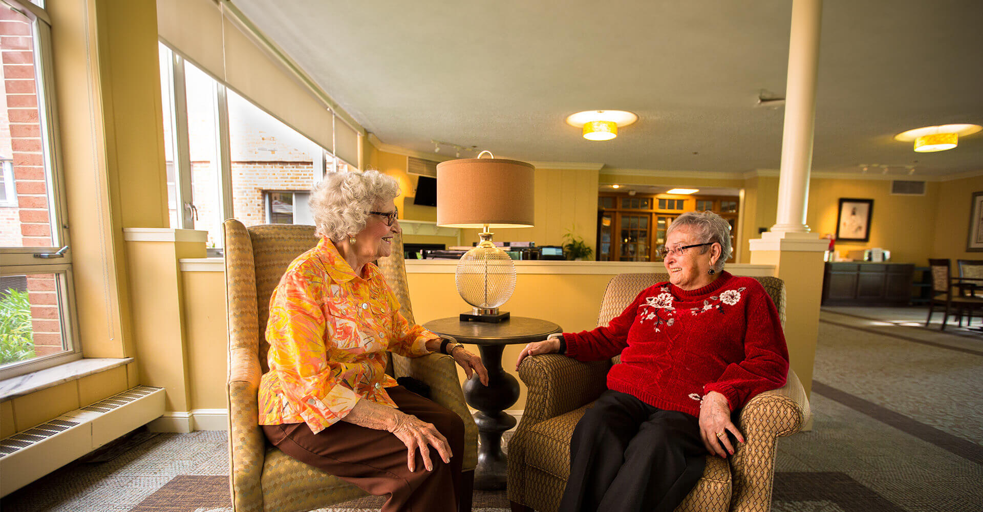 Senior friends chatting in a community common space.