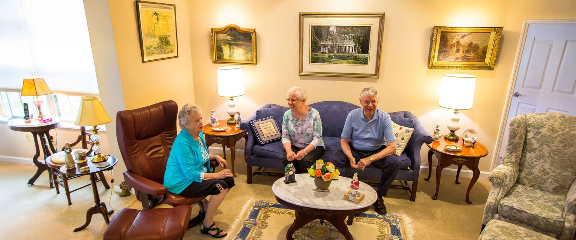 Seniors chatting in a resident's living room