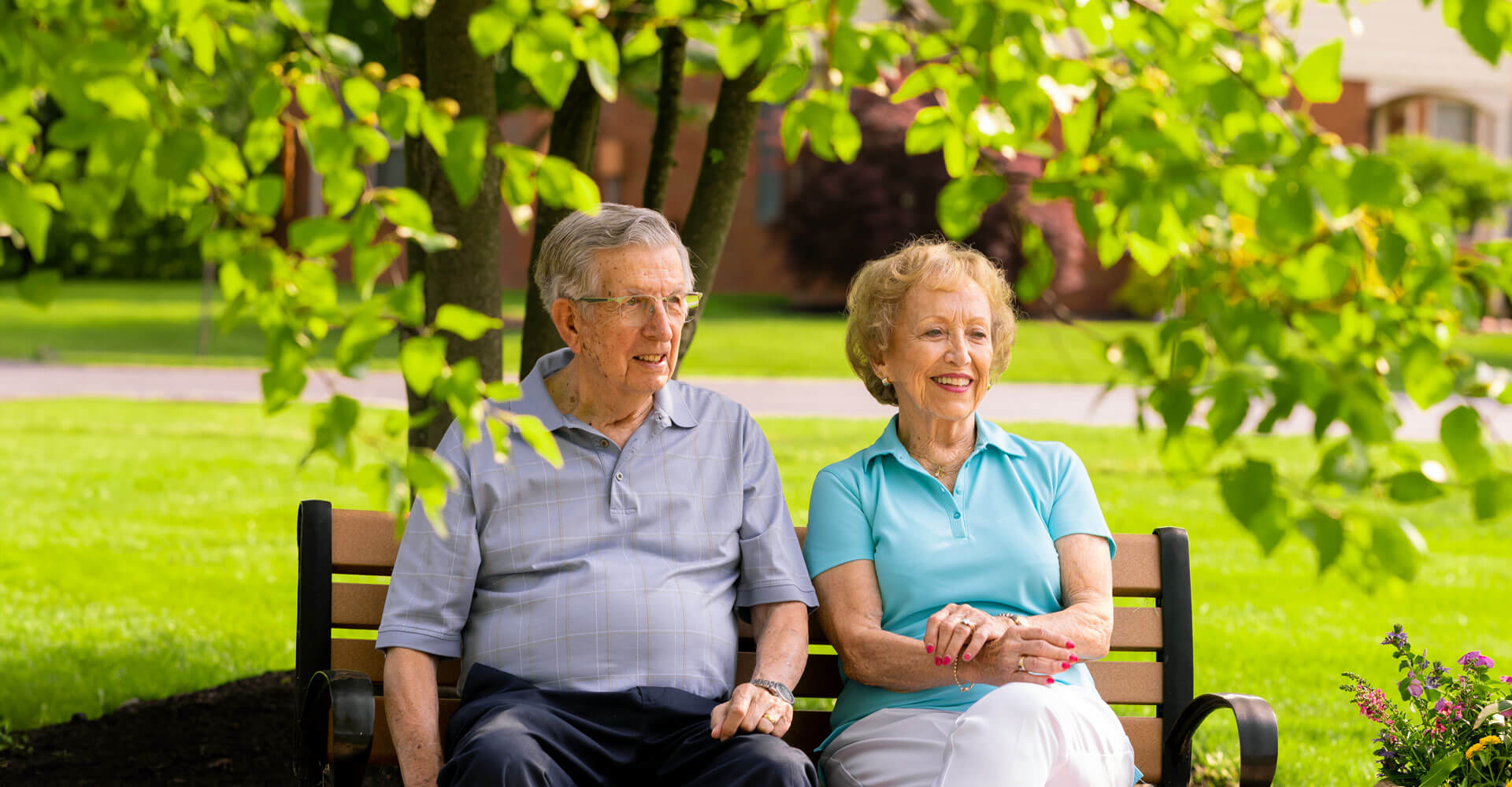 senior couple sitting on a bench outside