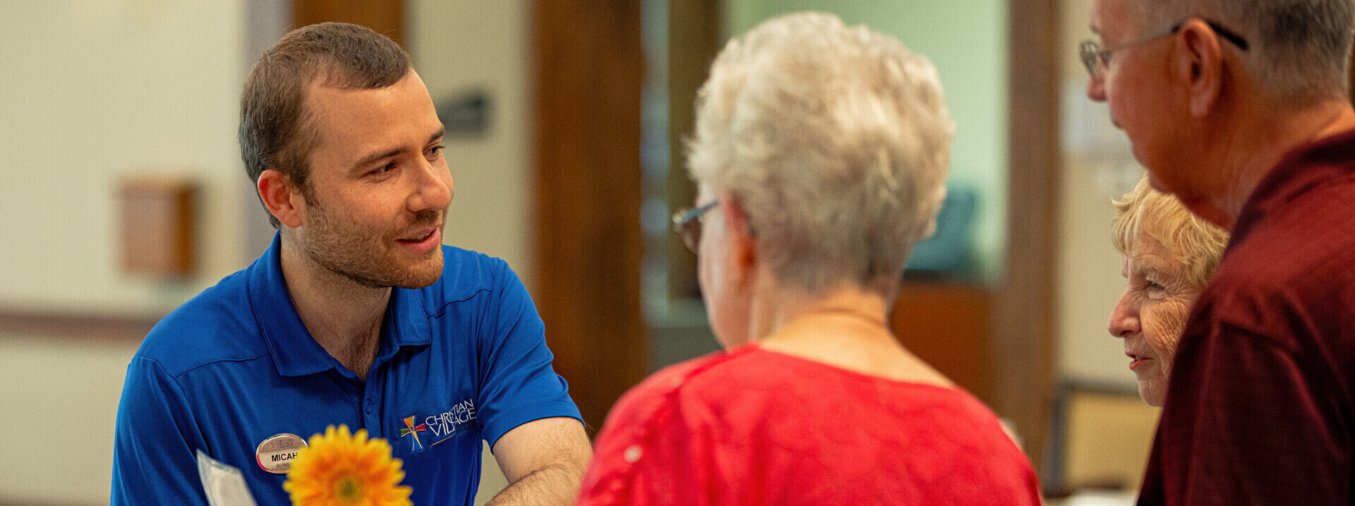 A staff member at The Christian Village at Mason assists two residents with the dining menu inside the on-site dining room.